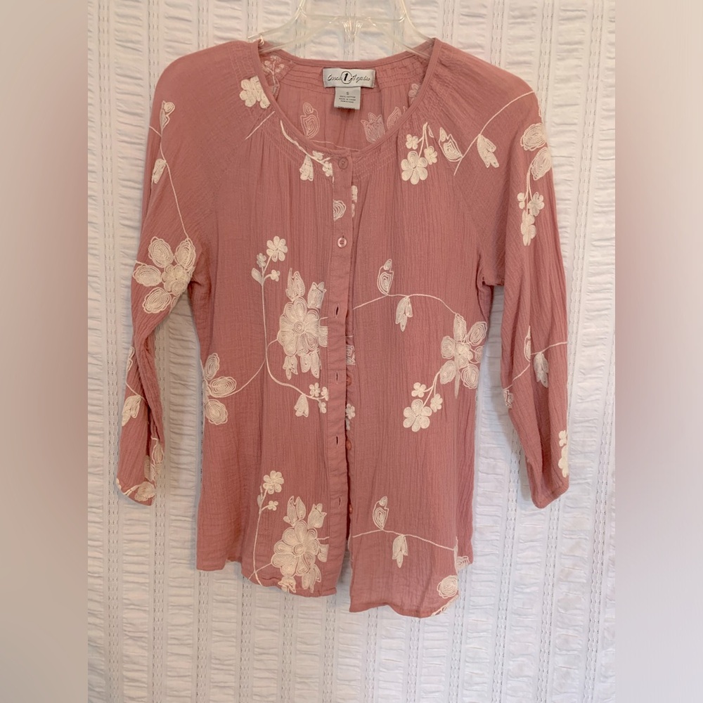 Women’s pink button-down blouse with floral stitching